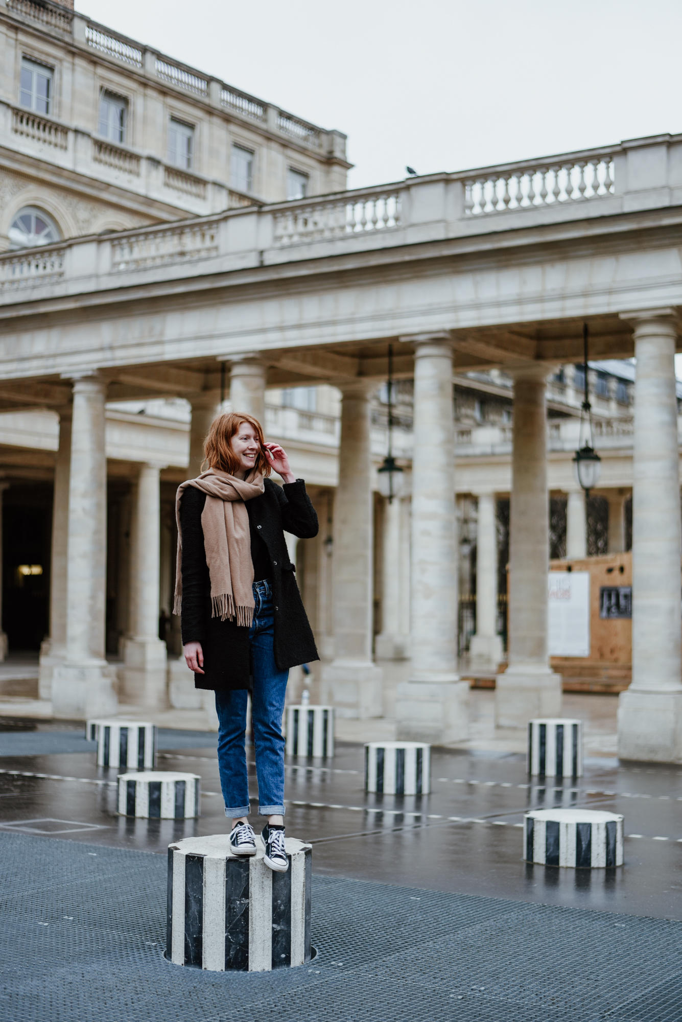 Girl with Les Deux Plateaux Colonnes de Buren at Palais Royal in Paris