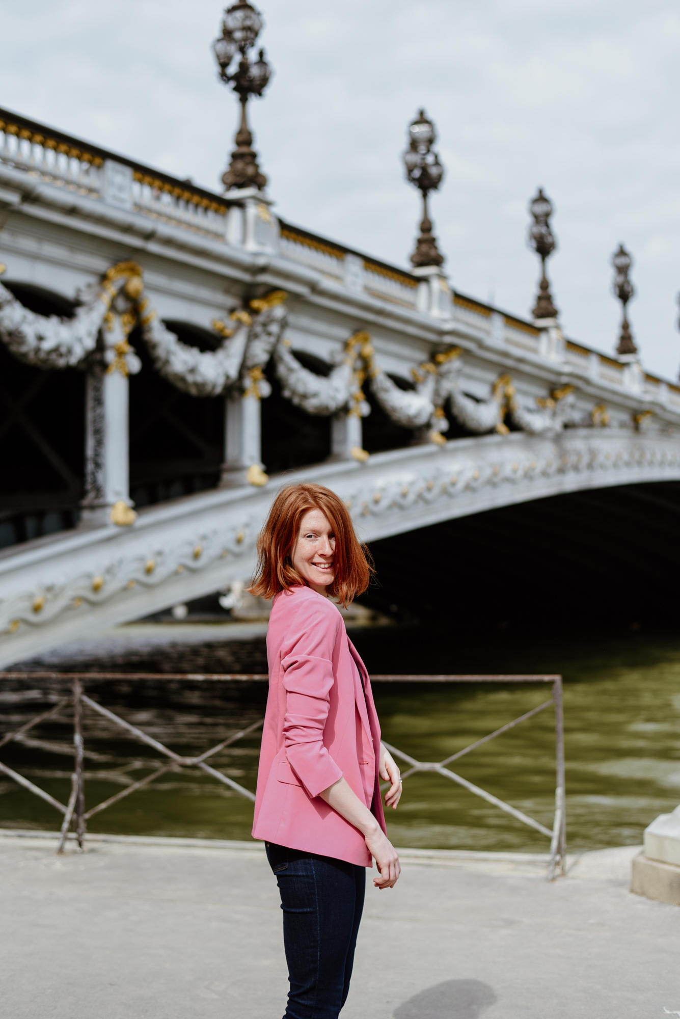 girl with pink jacket next to Pont Alexandre III in Paris
