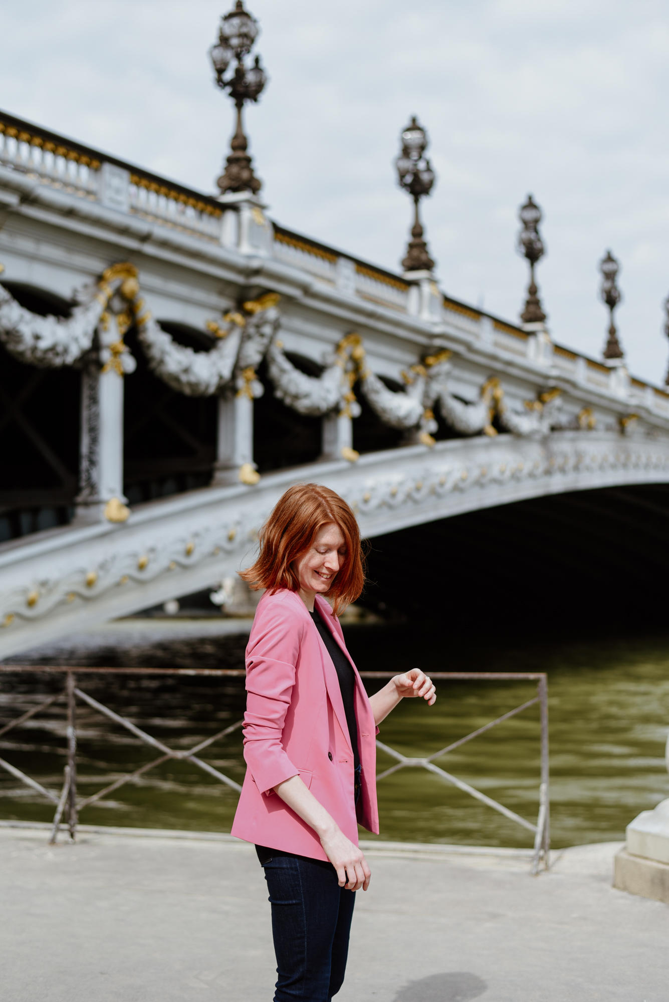 girl with pink jacket next to Pont Alexandre III in Paris