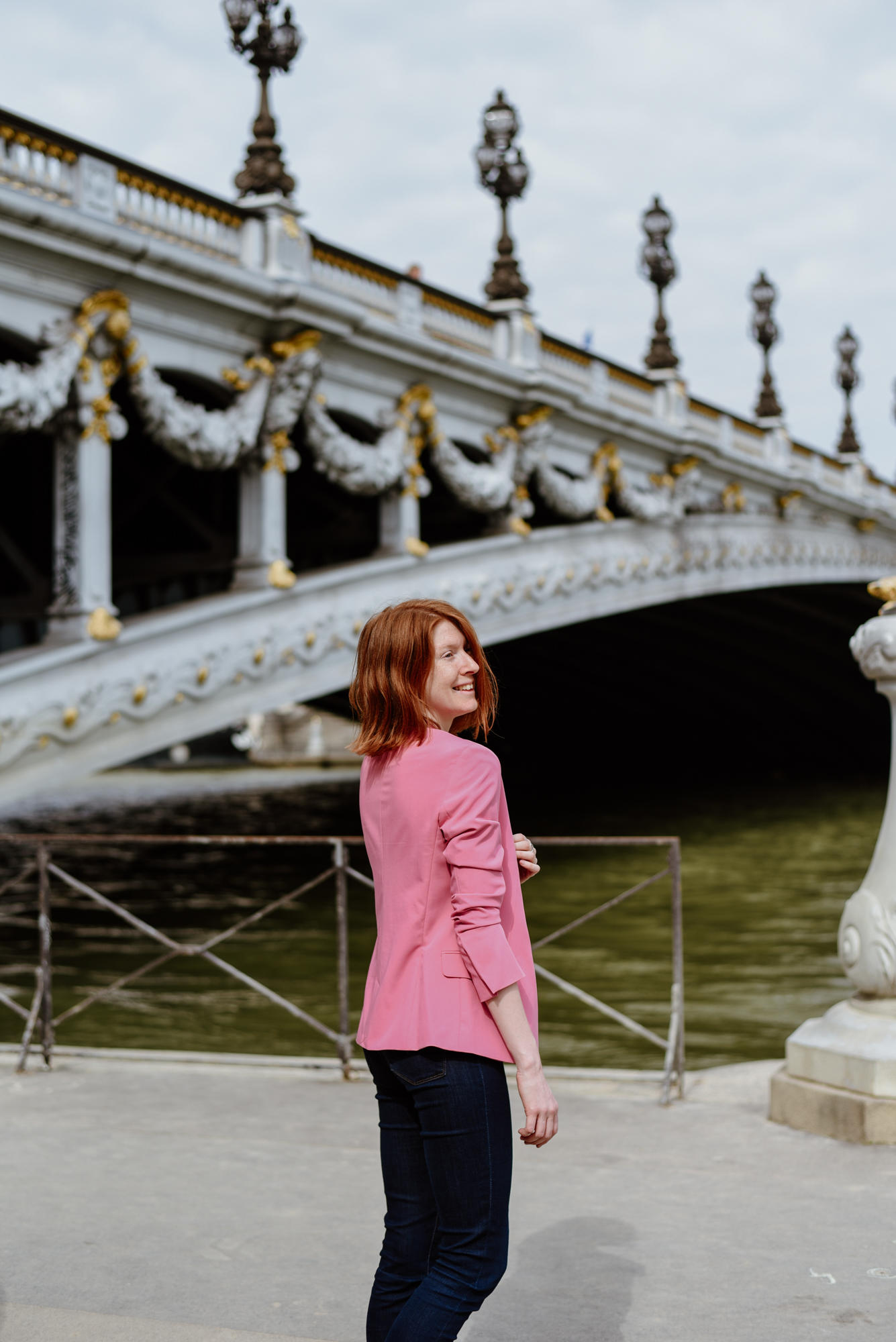 girl with pink jacket next to Pont Alexandre III in Paris